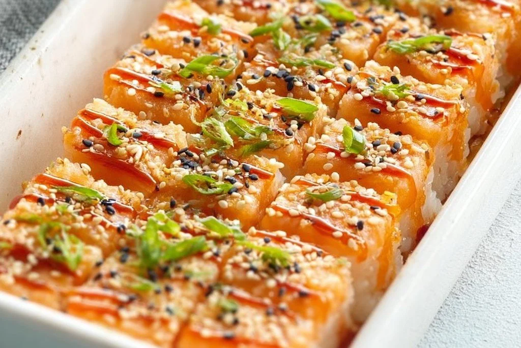 Sushi au saumon rôti au four avec garnitures fraîches et légumes.